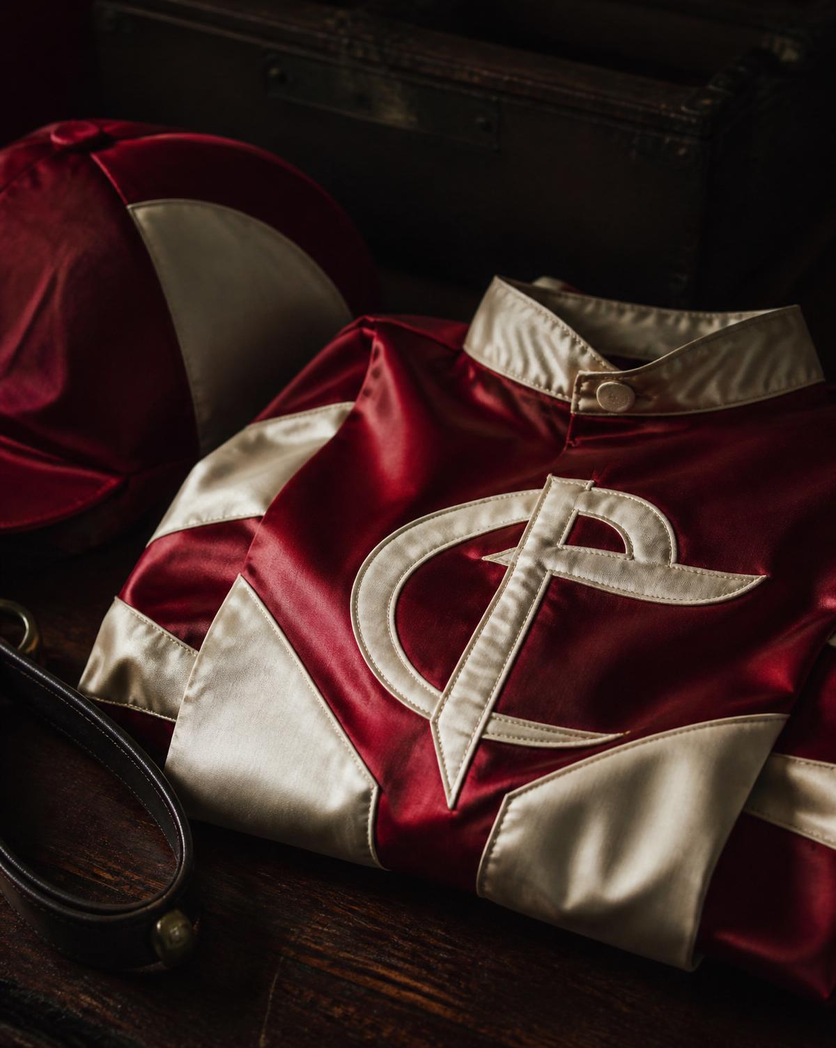 Folded jockey racing silks in crimson and cream